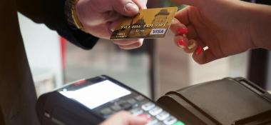Person hands a cashier a credit card