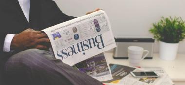 Man reads the business section of a newspaper